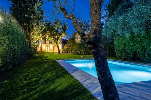 a swimming pool in a yard with a tree at Villa Lilla Bellagio - Luxury Pool and Wine with Lake view in Bellagio