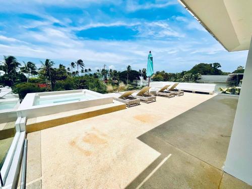 a patio with lounge chairs and a swimming pool at Pina Colada in Amphoe Koh Samui