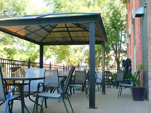 a patio with tables and chairs under a canopy at The Medicine Hat Villa in Medicine Hat