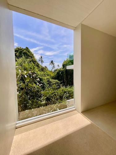 a window in a room with a view of a forest at Pina Colada in Amphoe Koh Samui