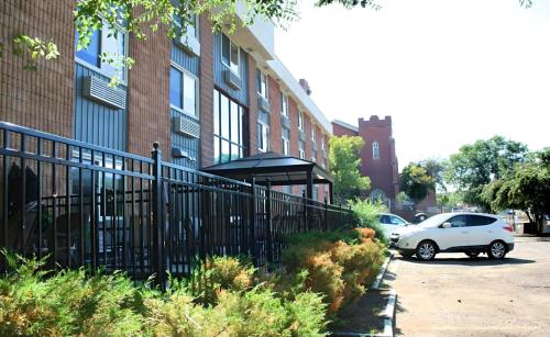 a white car parked in front of a building at The Medicine Hat Villa in Medicine Hat
