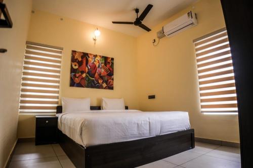 Zennova Furnished Apartment في أليبي: غرفة نوم بسرير ودهان على الحائط