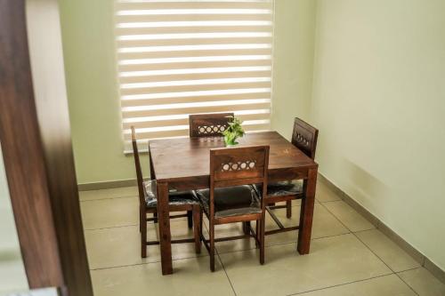 a wooden dining room table and chairs with a plant on it at Zennova Furnished Apartment in Alleppey