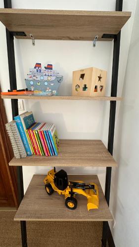 un camion de jouets sur une étagère avec des livres dans l'établissement Chambre Tropicale au Domaine de l'Aven, à Villeneuve-Minervois
