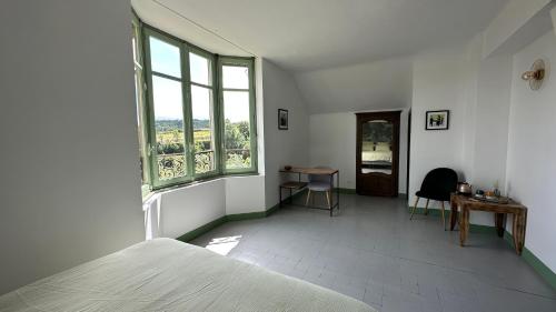une chambre avec un lit, un bureau et des fenêtres dans l'établissement Chambre Tropicale au Domaine de l'Aven, à Villeneuve-Minervois