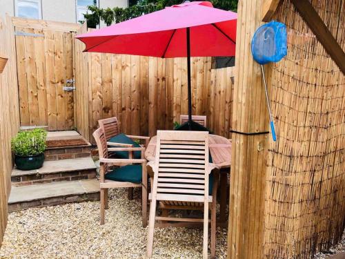 un tavolo da patio con ombrellone e sedie rossi di Stunning 3-Bed Cottage Hot Tub Wi-Fi Parking ad Appleby