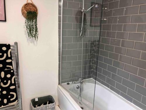 La salle de bains est pourvue d'une douche et d'une baignoire avec une porte en verre. dans l'établissement Inviting 3-Bed House in Sunderland WiFi Parking, à Sunderland