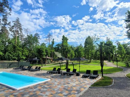 a pool with chairs and umbrellas in a park at Sunrise Sokirna in Sokirno