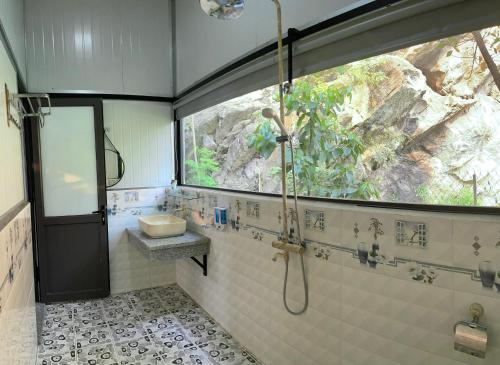 a bathroom with a shower and a sink and a window at Trang An Memory Homestay in Ninh Binh