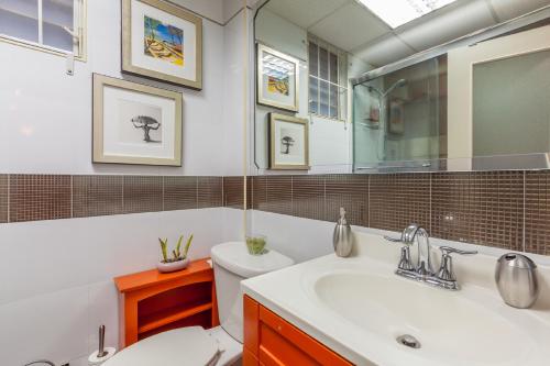 a bathroom with a sink and a toilet and a mirror at Choose To Be Happy at Seymour # 9 and #16 - Studio Apartments in Kingston