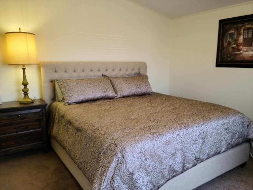 a bedroom with a bed and a lamp on a night stand at The Villa - Amazingly Comfortable King Beds in Alpine