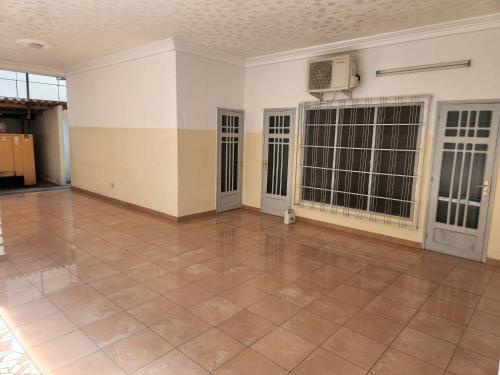 an empty room with two doors and a tile floor at Romo Cocotier in Cotonou