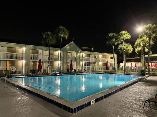 een groot zwembad voor een gebouw 's nachts bij Newly renovated room in cozy hotel near Disney in Kissimmee