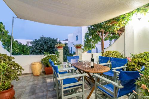 an outdoor patio with a wooden table and blue chairs at Kontaratos Studios & Apartments in Parikia