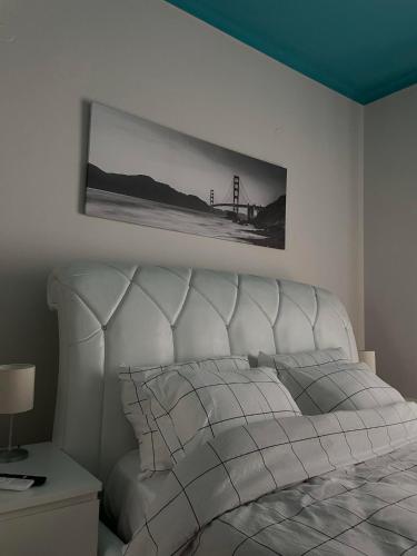 Un dormitorio con una cama blanca con una foto en la pared en Dream Central Appartment, en Tesalónica