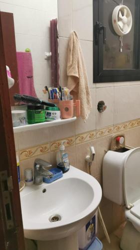 a bathroom with a white sink and a toilet at An appartment for rent in Ajman Alreqah Building in Ajman 