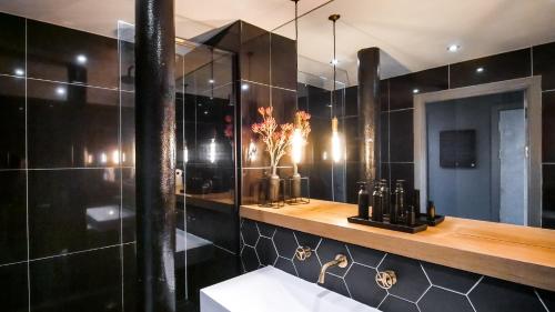 a black bathroom with a shower and a sink at New York by The Heim Residences in Manchester