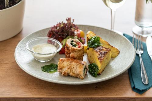 a plate of food on a table with a salad at Amicus Hotel in Vilnius