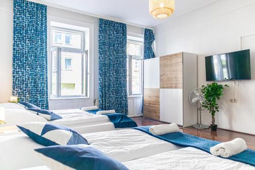 fila de camas en una habitación con paredes azules en Elegant Haven: Stylish and Spacious 3BR Apartment, en Viena