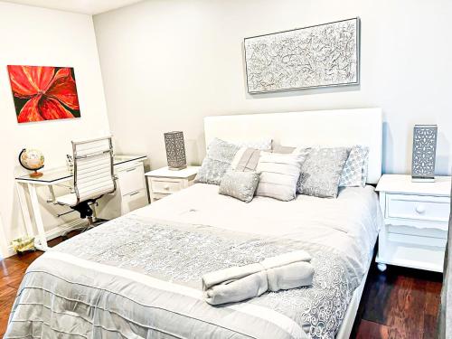 a bedroom with a large white bed and a desk at Modern 2-Bedroom Haven in the Heart of LA- HUD-VP in Los Angeles