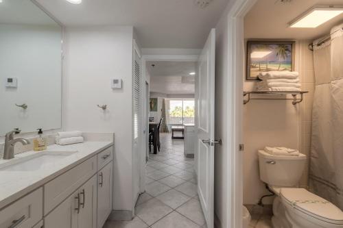 a white bathroom with a sink and a toilet at DBR Direct Oceanfront Condo, Daytona Beach, sleeps 6 in Daytona Beach