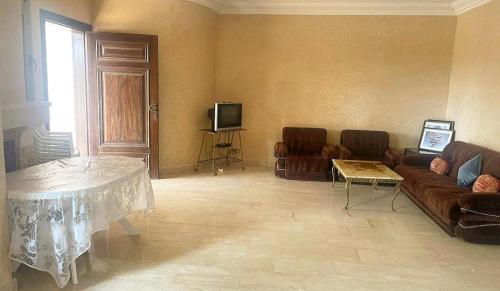 een woonkamer met een bank en een tafel bij Plage Skhirat in Skhirat