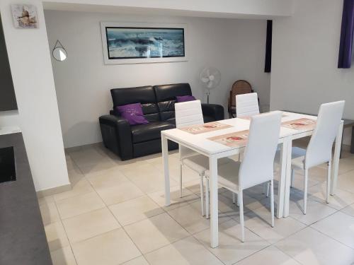 a living room with a table and chairs and a couch at Le gîte du temps suspendu in Anduze