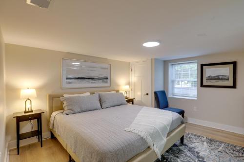 um quarto com uma cama e uma cadeira azul em Beautiful 3 BR Home with Workspace 20 Min to Boston em Bedford