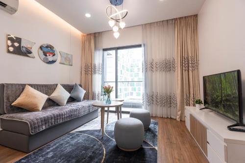 a living room with a couch and a tv at Republic Apartments Saigon Airport in Ho Chi Minh City