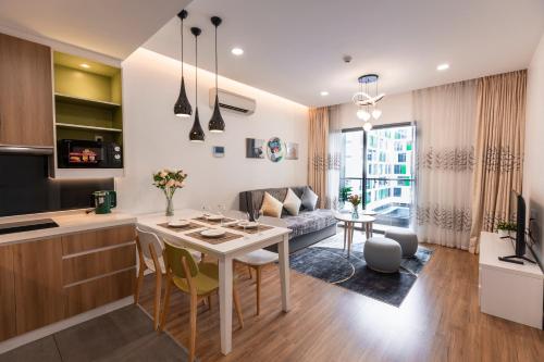 a kitchen and living room with a table and a couch at Republic Apartments Saigon Airport in Ho Chi Minh City