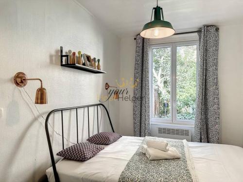 een slaapkamer met een bed met 2 kussens en een raam bij La Marine YourHostHelper in Trouville-sur-Mer