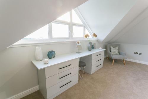 an attic office with a desk and a window at Garreg Hen in Trearddur