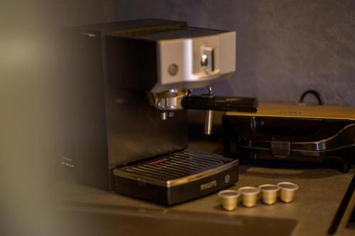 eine Kaffeemaschine auf einer Theke mit vier Tassen in der Unterkunft City Loft 1 (Stamatina's Luxury Apartments) in Alexandroupoli