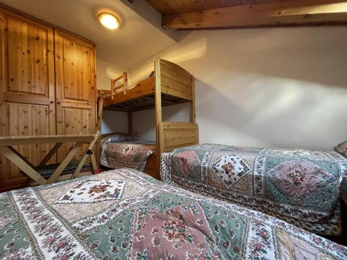 a bedroom with two beds and a bunk bed at Trilocale Il Cardo, Giustino in Giustino