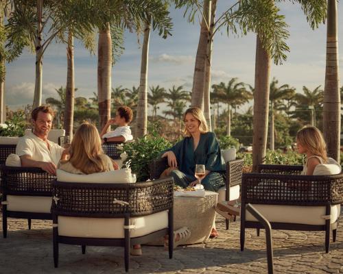 un grupo de personas sentadas en sillas en un patio en Apes Hill Barbados Golf and Resort Community, en Saint James