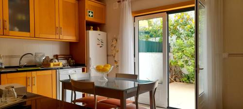 eine Küche mit einem Glastisch und einem Esszimmer in der Unterkunft Casa dos Limões in Caldas da Rainha