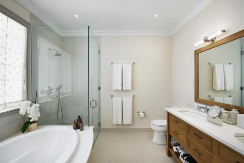 a bathroom with a tub and a sink and a toilet at Apes Hill Barbados Golf and Resort Community in Saint James