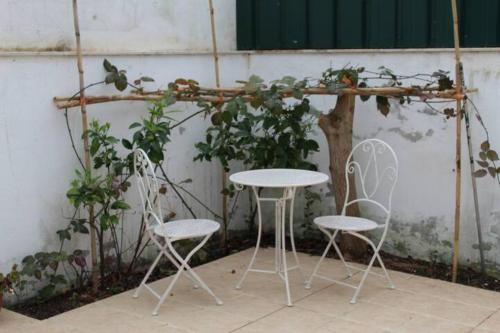 Deux chaises, une table et deux tables et chaises dans l'établissement Casa dos Limões, à Caldas da Rainha