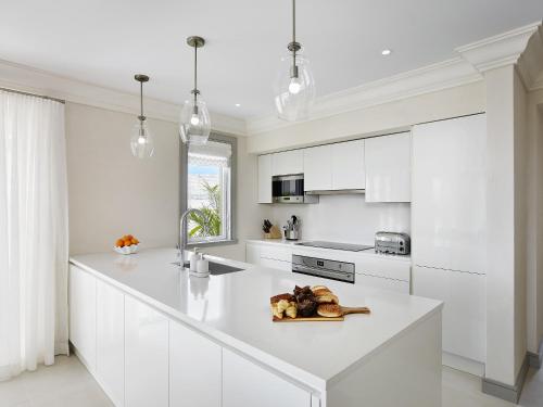 una cocina blanca con una gran encimera blanca en Apes Hill Barbados Golf and Resort Community, en Saint James