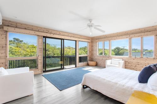 a bedroom with a bed and large windows at Fire Island Pines Rooms in Fire Island Pines