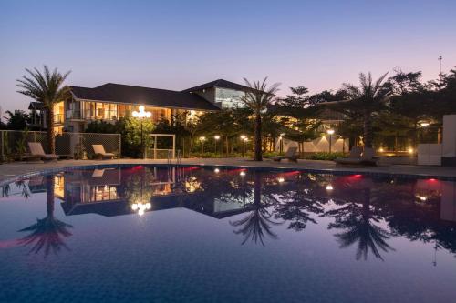 a swimming pool in front of a house at night at Global Village Luxury Resort in Chikmagalūr