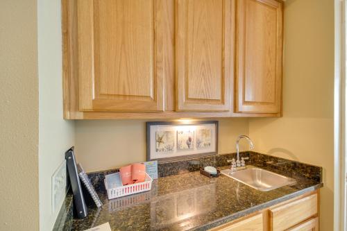 a kitchen with a sink and wooden cabinets at Beachfront Gulfport Vacation Rental with Balcony! in Gulfport