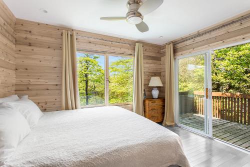 a bedroom with a bed and a large window at The Pines Men-Only Stay in Fire Island Pines