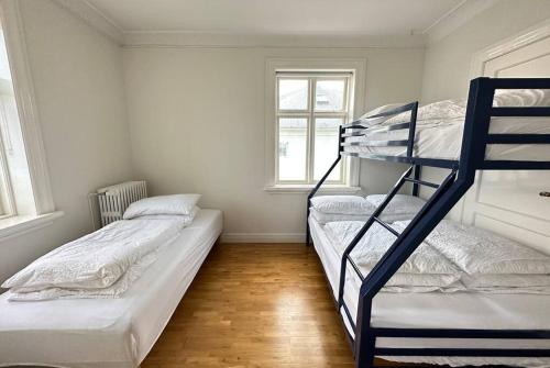 two bunk beds in a room with two windows at Beautiful 2 bedroom apartment downtown Reykjavik in Reykjavík
