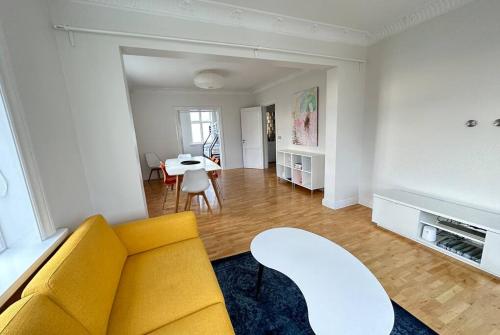a living room with a yellow couch and a table at Beautiful 2 bedroom apartment downtown Reykjavik in Reykjavík