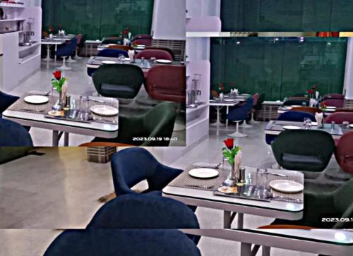 a dining room with tables and chairs with red roses on them at Hotel Omni Plaza in Jodhpur