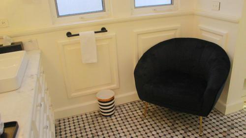 a bathroom with a black chair next to a sink at Esciros in Chicxulub