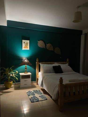 um quarto com uma cama e uma parede verde em Khael Glory home offers 247 security em Kampala