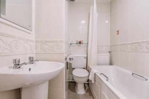 a bathroom with a sink and a toilet and a bath tub at Muthu Westcliff Hotel (Near London Southend Airport) in Southend-on-Sea