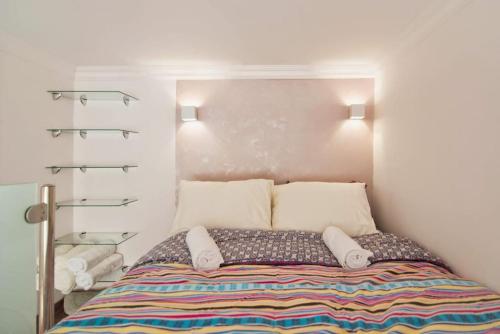 - une chambre avec un lit doté d'oreillers et d'étagères dans l'établissement Gallery studio apartment, à Tel Aviv